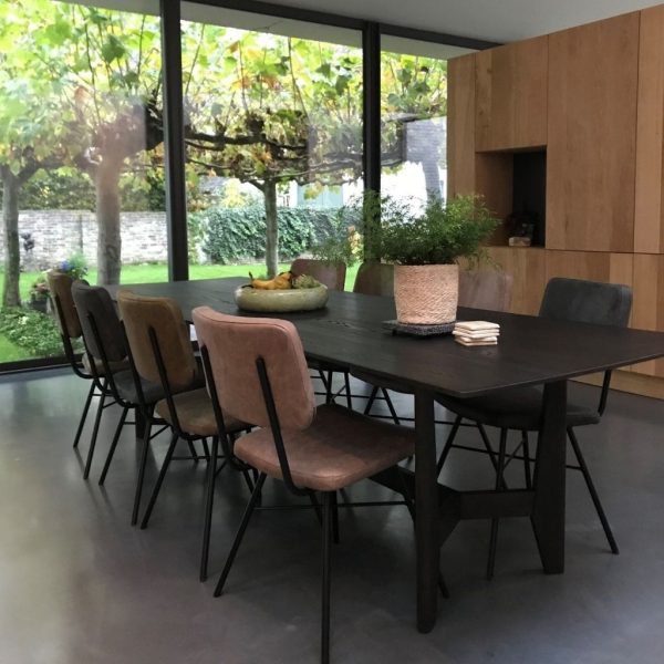 Verschillende kleuren stoelen aan de eettafel