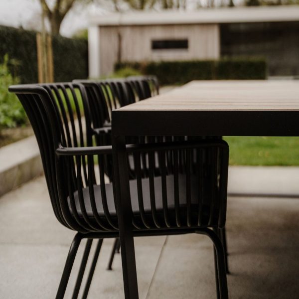 Zwarte tuinstoel Otis aan Iroko houten tuintafel