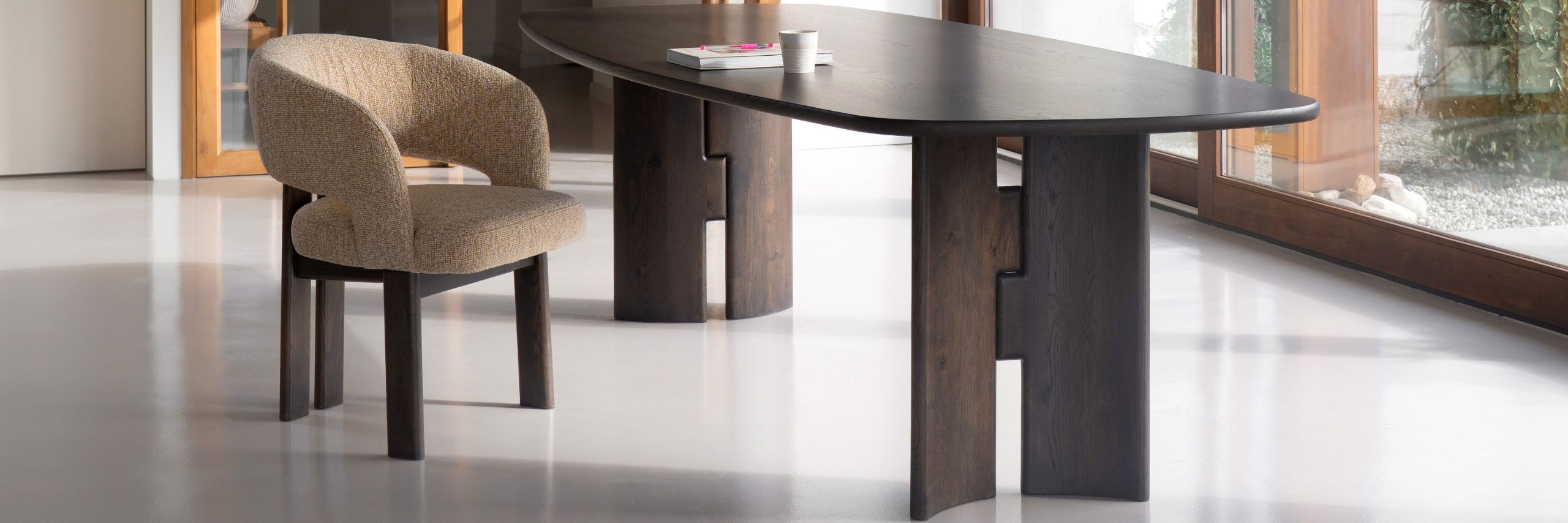 Donkere noten houten eettafel met massief houten wangonderstel en luxe eetkamerstoel met houten poten