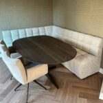 Stoffen eetkamerbank Kuub in hoekopstelling met doorgestikte naden en doorlopend onderstel.