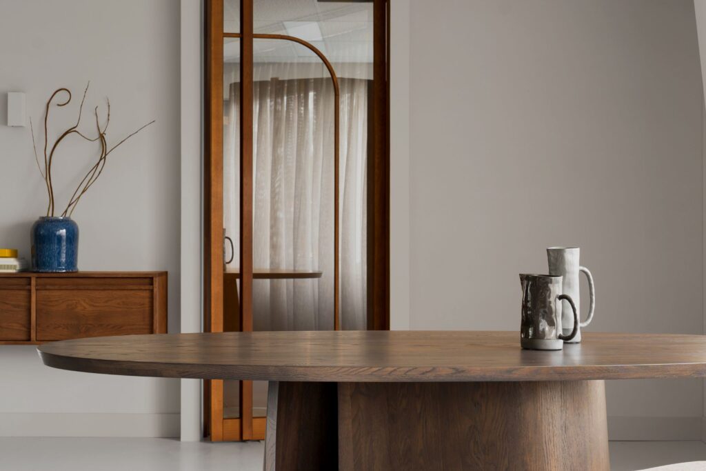 Ovale houten tafel voor een houten deur met glas