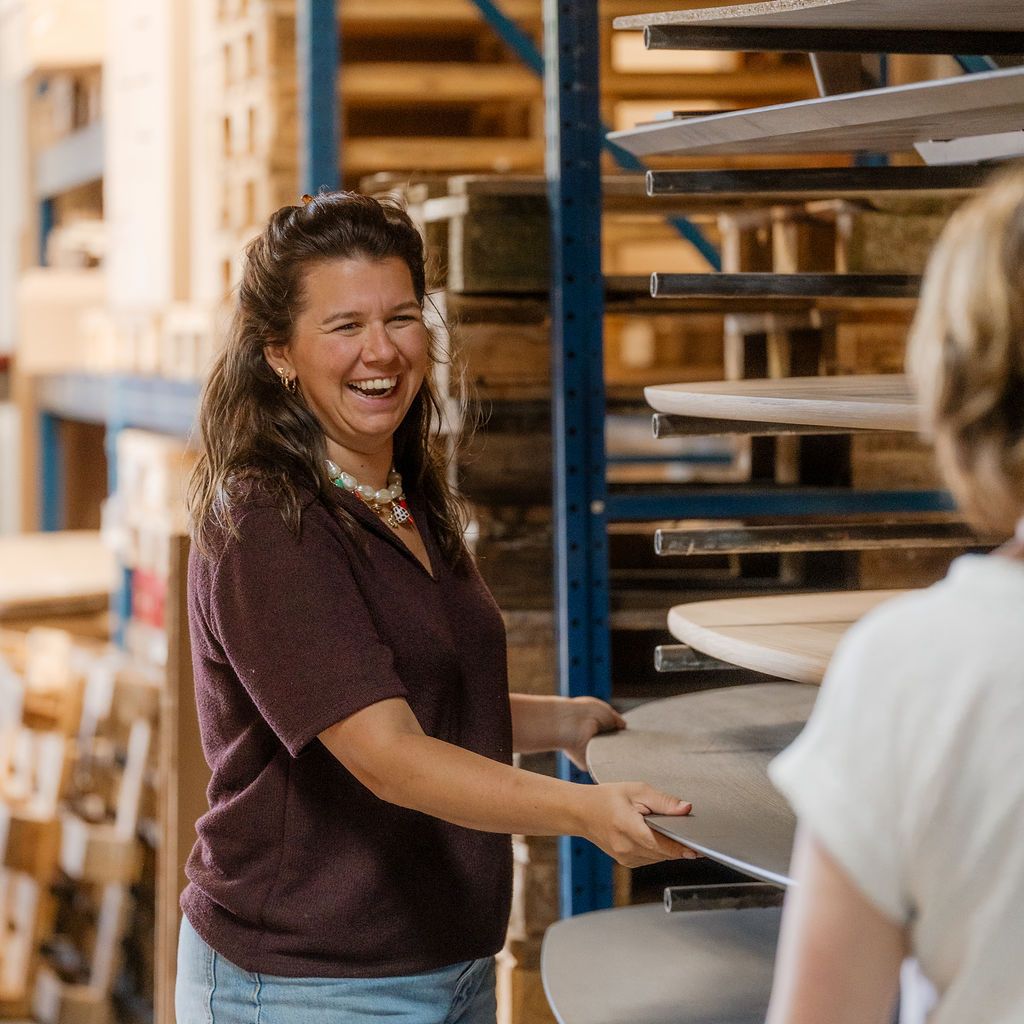 Pleun laat verschillende vormen tafelbladen zien in de werkplaats van Van Tafel